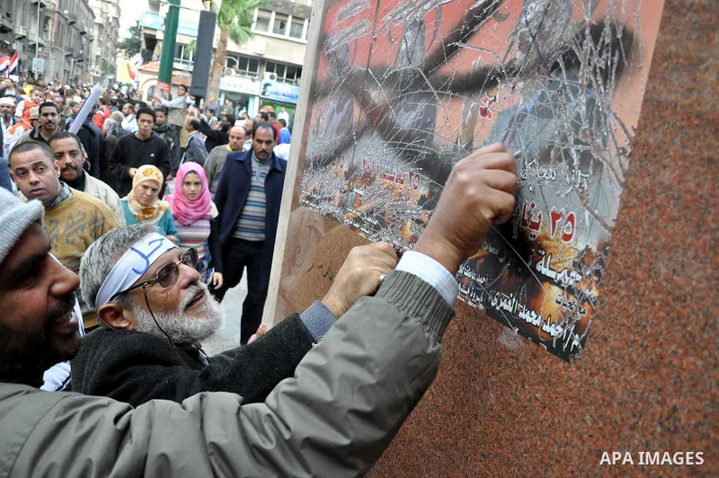 Egyptian protesters damage posters depicting President Hosni Mubarak during a protest called 'Sunday of the martyrs' in Alexandria, Egypt, 06 February 2011. Anti-government protests entered its 13th straight day in Egypt...