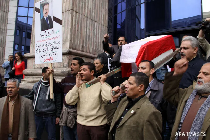 People carry a symbolic coffin of Egyptian journalist Ahmed Mohammed Mahmoud, in symbolic funeral ceremony in Tahrir Square, Cairo, Egypt, Monday, Feb. 7, 2011. The reporter who was shot during clashes a week ago died of...