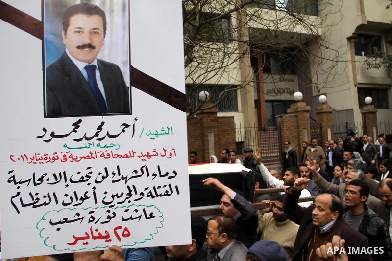 People carry a symbolic coffin of Egyptian journalist Ahmed Mohammed Mahmoud, in symbolic funeral ceremony in Tahrir Square, Cairo, Egypt, Monday, Feb. 7, 2011. The reporter who was shot during clashes a week ago died of...