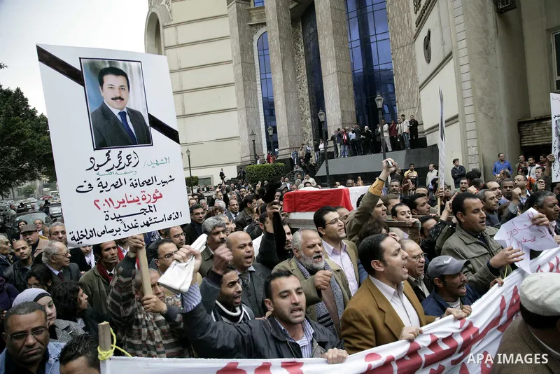 People carry a symbolic coffin of Egyptian journalist Ahmed Mohammed Mahmoud, in symbolic funeral ceremony in Tahrir Square, Cairo, Egypt, Monday, Feb. 7, 2011. The reporter who was shot during clashes a week ago died of...
