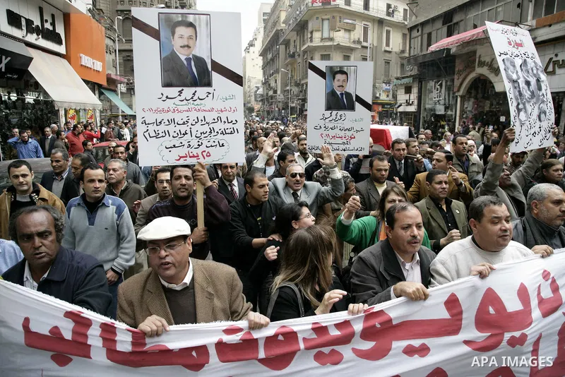 People carry a symbolic coffin of Egyptian journalist Ahmed Mohammed Mahmoud, in symbolic funeral ceremony in Tahrir Square, Cairo, Egypt, Monday, Feb. 7, 2011. The reporter who was shot during clashes a week ago died of...