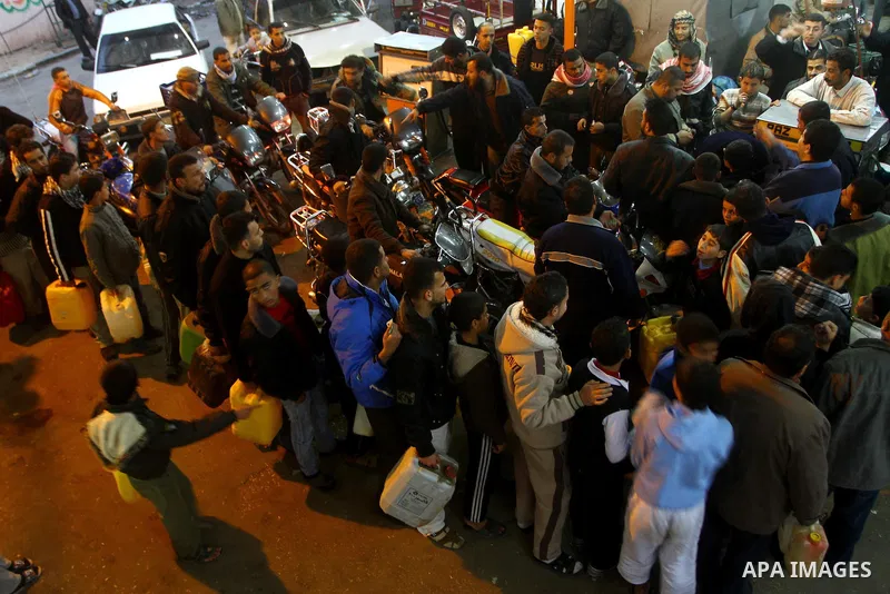 Palestinians wait to fill petrol in containers at a petrol station in Gaza city on Feb. 7, 2011. Gaza Strip residents flocked to petrol stations after clashes in neighbouring Egypt hampered smugglers ferrying fuel suppli...