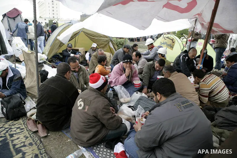Egyptian anti-government protesters eat in Tahrir Square in Cairo, Egypt, Monday, Feb. 7, 2011. The protests, which saw tens of thousands of people massing daily in downtown Cairo for demonstrations that at times turned...
