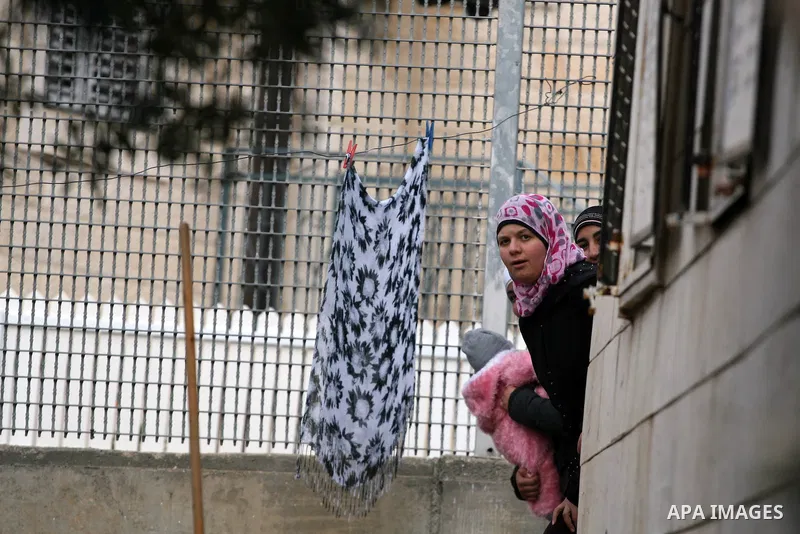 Palestinians are seen in the fenced in back yard of the Sabri Gareeb family home which is situated in the center of the Givon Ha Hadasha Jewish settlement just south of Ramallah in the Israeli occupied West Bank on Febru...