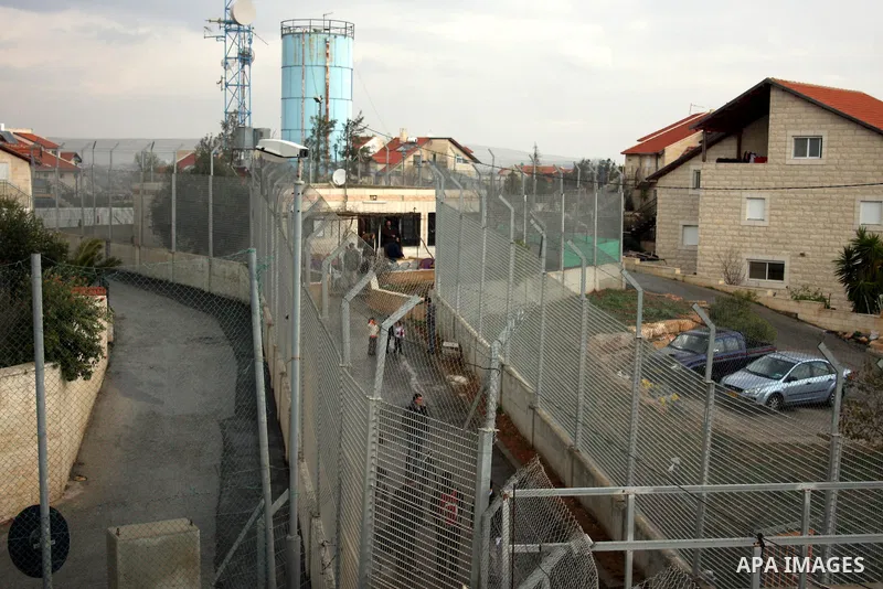 Palestinians are seen in the fenced in back yard of the Sabri Gareeb family home which is situated in the center of the Givon Ha Hadasha Jewish settlement just south of Ramallah in the Israeli occupied West Bank on Febru...