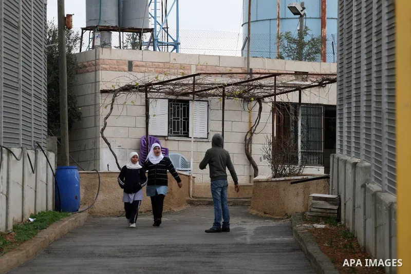 Palestinians are seen in the fenced in back yard of the Sabri Gareeb family home which is situated in the center of the Givon Ha Hadasha Jewish settlement just south of Ramallah in the Israeli occupied West Bank on Febru...