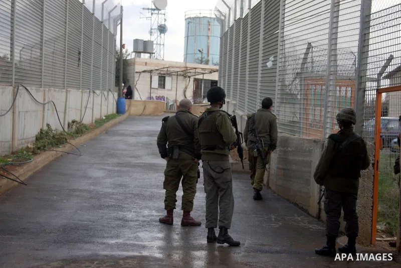 Israeli soldiers are seen in the fenced in back yard of the Sabri Gareeb family home which is situated in the center of the Givon Ha Hadasha Jewish settlement just south of Ramallah in the Israeli occupied West Bank on F...
