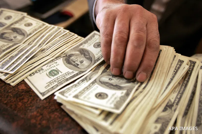 A Palestinian man displays money at his exchanges currency shop in the southern Gaza Strip town of Rafah on Feb. 2011. Photo by Abed Rahim Khatib