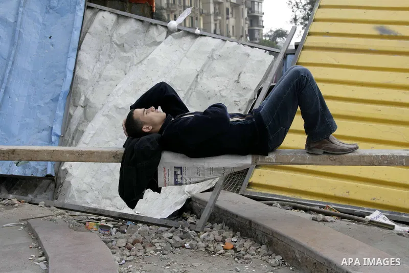 Anti-government protester sleeps in Tahrir Square in downtown Cairo, Egypt, Tuesday, Feb. 8, 2011. Protesters appear to have settled in for a long standoff, turning Tahrir Square into a makeshift village with tens of tho...