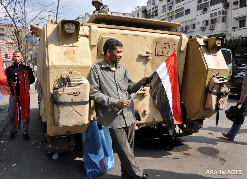 Anti-government protester stands next a tank during demonstrations in Tahrir Square in downtown Cairo, Egypt, Tuesday, Feb. 8, 2011. Protesters appear to have settled in for a long standoff, turning Tahrir Square into a...