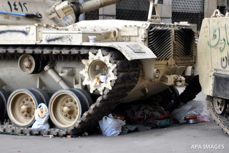 Anti-government protesters put their belongings under a tank during demonstrations in Tahrir Square in downtown Cairo, Egypt, Tuesday, Feb. 8, 2011. Protesters appear to have settled in for a long standoff, turning Tahri...