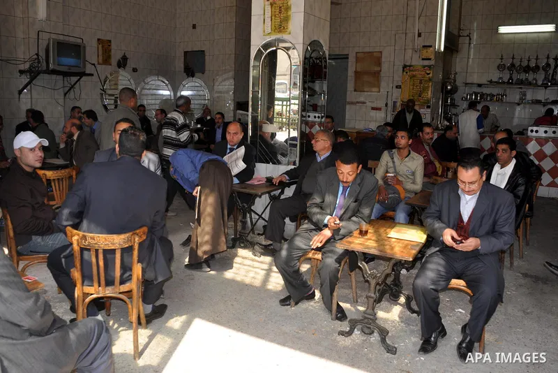 Egyptians sit in coffe shop in Cairo, Egypt, Tuesday, Feb. 8, 2011. Protesters appear to have settled in for a long standoff, turning Tahrir Square into a makeshift village with tens of thousands coming every day, with s...