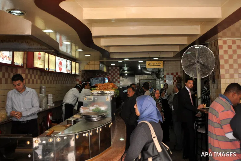Egyptians eat at a resturant in Cairo, Egypt, Tuesday, Feb. 8, 2011. Protesters appear to have settled in for a long standoff, turning Tahrir Square into a makeshift village with tens of thousands coming every day, with...