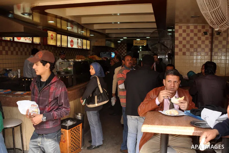 Egyptians eat at a resturant in Cairo, Egypt, Tuesday, Feb. 8, 2011. Protesters appear to have settled in for a long standoff, turning Tahrir Square into a makeshift village with tens of thousands coming every day, with...
