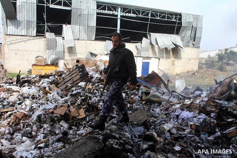 A Palestinian Hamas policeman inspects burnt a medical storage facility a day after it was set on fire following an Israeli air strike in Jabalia, northern Gaza Strip, on February 9, 2011. Photo by Ashraf Amra