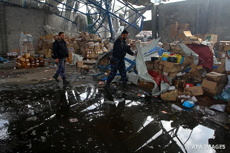 Palestinian Hamas policemen inspect burnt a medical storage facility a day after it was set on fire following an Israeli air strike in Jabalia, northern Gaza Strip, on February 9, 2011. Photo by Ashraf Amra