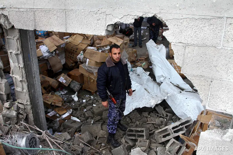 A Palestinian Hamas policeman inspects burnt a medical storage facility a day after it was set on fire following an Israeli air strike in Jabalia, northern Gaza Strip, on February 9, 2011. Photo by Ashraf Amra