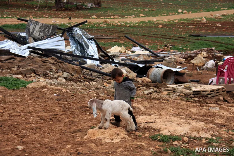 A Palestinian boy walks after the Civil Administration demolished constructions in the village of Khirbet Tana near the West Bank city of Nablus, Wednesday, Feb. 9, 2011. According to Palestinian witnesses and an Israeli...