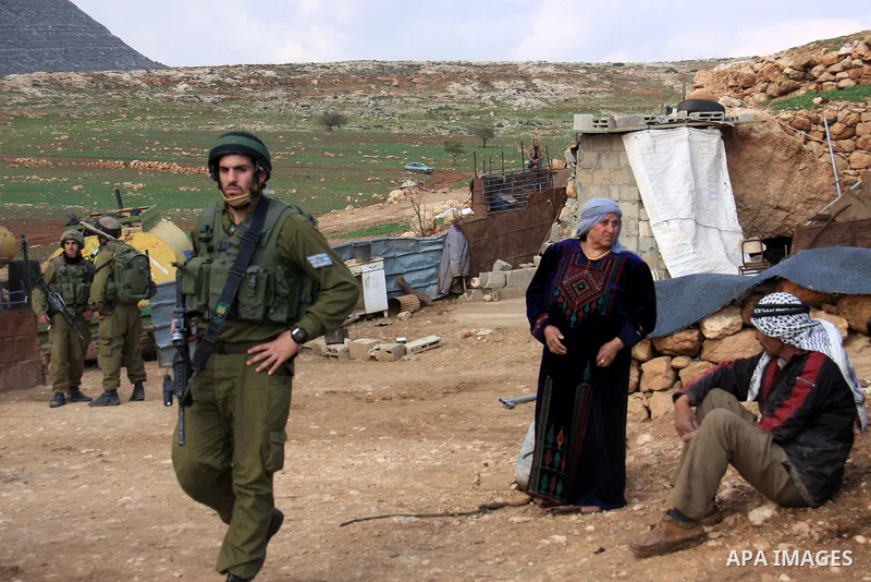 Israeli soldiers stand guards as a bulldozer of the Civil Administration during a demolition in the village of Khirbet Tana near the West Bank city of Nablus, Wednesday, Feb. 9, 2011. According to Palestinian witnesses a...