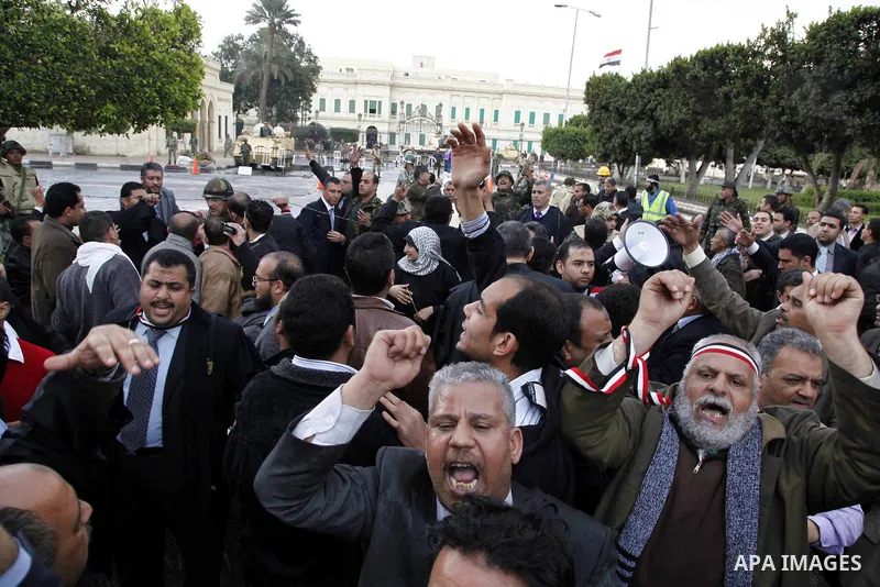 Egyptian protesters demonstrate at the gate of the presidential palace in Cairo, Egypt, Thursday, Feb. 10, 2011. Egypt's foreign minister warns of a military coup if protesters continue mass demonstrations and don't foll...