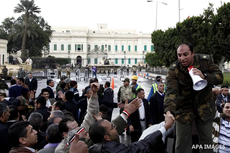 Egyptian protesters demonstrate at the gate of the presidential palace in Cairo, Egypt, Thursday, Feb. 10, 2011. Egypt's foreign minister warns of a military coup if protesters continue mass demonstrations and don't foll...