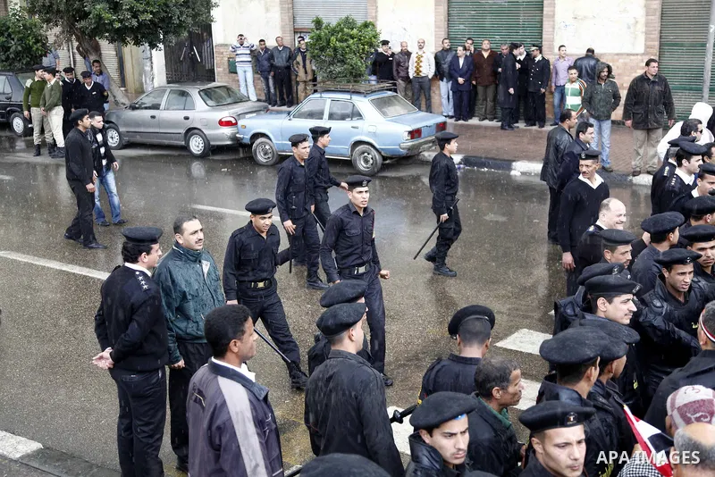 Egyptian policemen stands guard as protesters demonstrate at the gate of the presidential palace in Cairo, Egypt, Thursday, Feb. 10, 2011. Egypt's foreign minister warns of a military coup if protesters continue mass dem...
