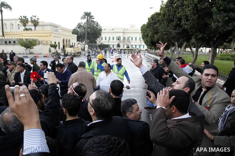 Egyptian protesters demonstrate at the gate of the presidential palace in Cairo, Egypt, Thursday, Feb. 10, 2011. Egypt's foreign minister warns of a military coup if protesters continue mass demonstrations and don't foll...