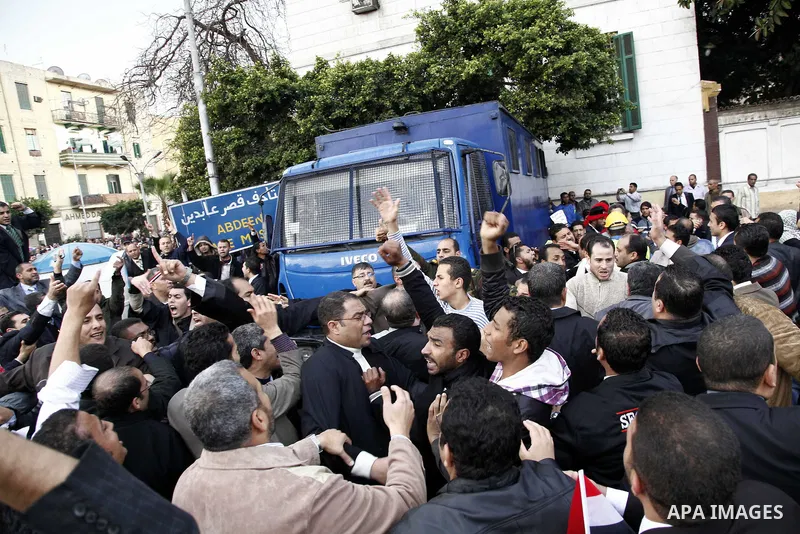 Egyptian protesters demonstrate at the gate of the presidential palace in Cairo, Egypt, Thursday, Feb. 10, 2011. Egypt's foreign minister warns of a military coup if protesters continue mass demonstrations and don't foll...