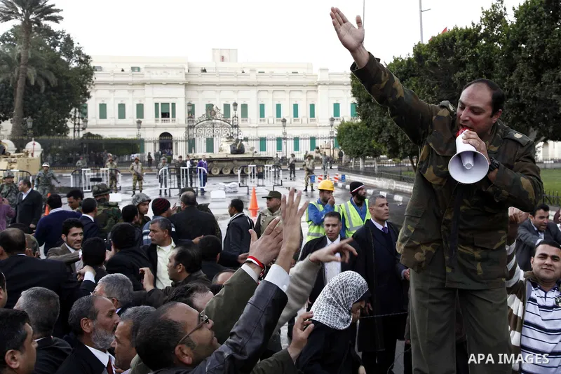 Egyptian protesters demonstrate at the gate of the presidential palace in Cairo, Egypt, Thursday, Feb. 10, 2011. Egypt's foreign minister warns of a military coup if protesters continue mass demonstrations and don't foll...