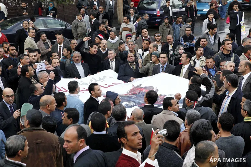 Egyptian protesters demonstrate at the gate of the presidential palace in Cairo, Egypt, Thursday, Feb. 10, 2011. Egypt's foreign minister warns of a military coup if protesters continue mass demonstrations and don't foll...