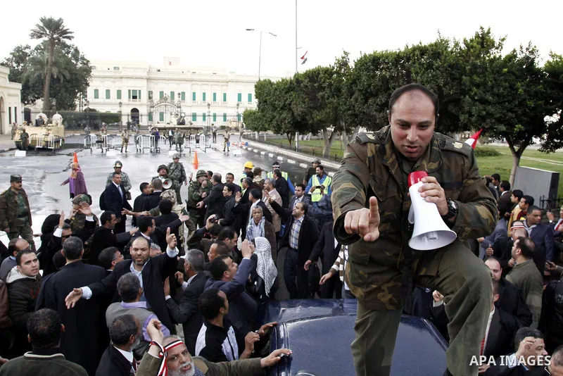 Egyptian protesters demonstrate at the gate of the presidential palace in Cairo, Egypt, Thursday, Feb. 10, 2011. Egypt's foreign minister warns of a military coup if protesters continue mass demonstrations and don't foll...