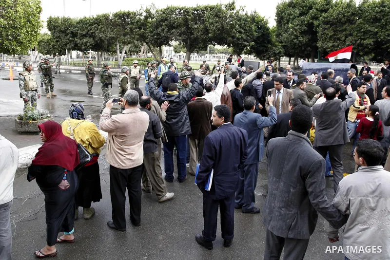 Egyptian protesters demonstrate at the gate of the presidential palace in Cairo, Egypt, Thursday, Feb. 10, 2011. Egypt's foreign minister warns of a military coup if protesters continue mass demonstrations and don't foll...