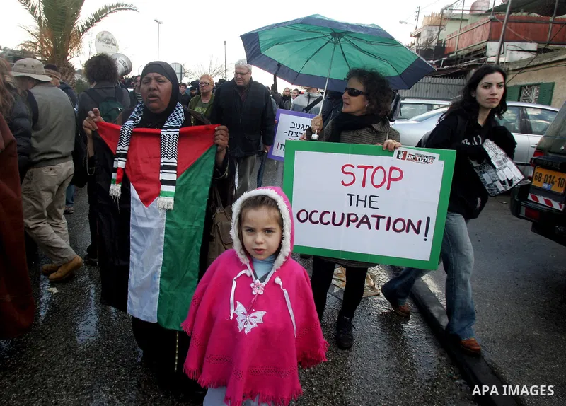 Palestinians, Israelis and foreign activists hold signs during a protest to show solidarity with Palestinian families against a Jewish settlement in the Sheikh Jarrah neighbourhood in East Jerusalem on Feb. 11, 2011. Pho...