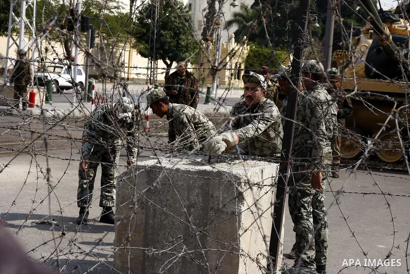 Egyptian Presidential guards block the entrence to Ettehadyya Presidential palace with barbed wire as Egyptian anti-government protesters march in Cairo, Egypt, Friday, Feb. 11, 2011. Egypt's military seemed to throw its...