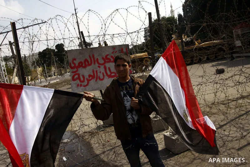 Anti-government protesters gather in front of Army soldiers protecting an entrance the entrence to Ettehadyya Presidential palace in Cairo, Egypt, Friday, Feb. 11, 2011. Egypt's military seemed to throw its weight Friday...