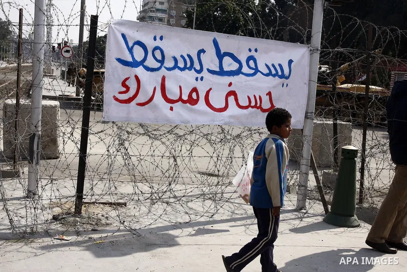 Anti-government protesters gather in front of Army soldiers protecting an entrance the entrence to Ettehadyya Presidential palace in Cairo, Egypt, Friday, Feb. 11, 2011. Egypt's military seemed to throw its weight Friday...