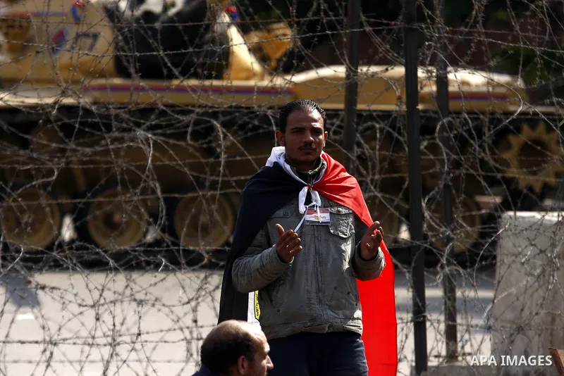 Egyptian protesters pray as the army block the entrence to Ettehadyya Presidential palace by barbed wire in Cairo, Egypt, Friday, Feb. 11, 2011. Egypt's military seemed to throw its weight Friday behind President Hosni M...