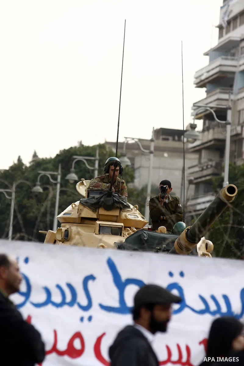Anti-government protesters gather in front of Army soldiers protecting an entrance the entrence to Ettehadyya Presidential palace in Cairo, Egypt, Friday, Feb. 11, 2011. Egypt's military seemed to throw its weight Friday...