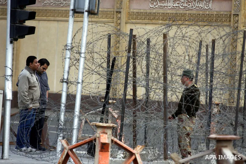 Anti-government protesters gather in front of Army soldiers protecting an entrance the entrence to Ettehadyya Presidential palace in Cairo, Egypt, Friday, Feb. 11, 2011. Egypt's military seemed to throw its weight Friday...