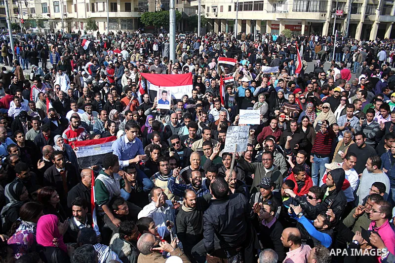 Egyptian anti-government protesters shout in front of Ettehadyya Presidential palace in Cairo, Egypt, Friday, Feb. 11, 2011. Egypt's military seemed to throw its weight Friday behind President Hosni Mubarak's plan to sta...
