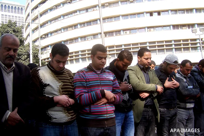 Anti-government protesters pray in front the state television building in Cairo, Egypt, Friday, Feb. 11, 2011. Mubarak has refused to step down or leave the country, and instead handed his administrative powers to his vi...