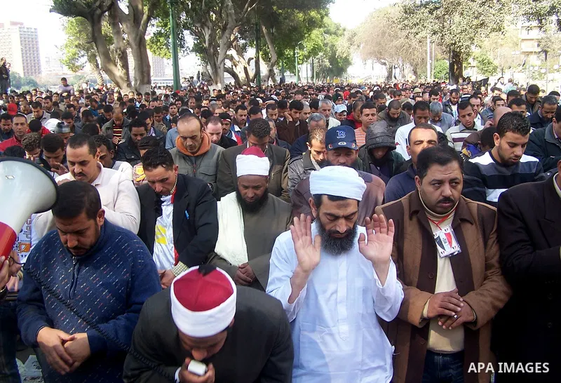 Anti-government protesters pray in front the state television building in Cairo, Egypt, Friday, Feb. 11, 2011. Mubarak has refused to step down or leave the country, and instead handed his administrative powers to his vi...