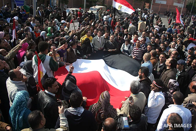 Egyptian anti-government protesters shout in front of Ettehadyya Presidential palace in Cairo, Egypt, Friday, Feb. 11, 2011. Egypt's military seemed to throw its weight Friday behind President Hosni Mubarak's plan to sta...