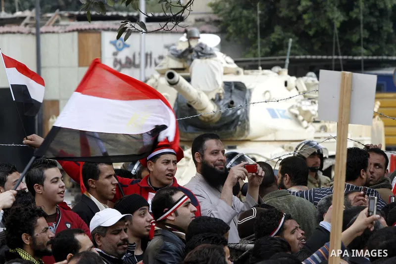 Anti-government protesters gather in front the state television building in Cairo, Egypt, Friday, Feb. 11, 2011. Mubarak has refused to step down or leave the country, and instead handed his administrative powers to his...