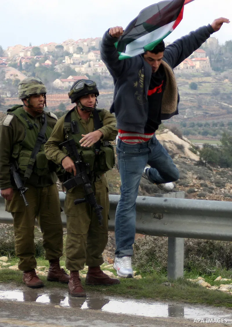 Israeli soldiers restrain Palestinian ,Israeli and foreign protesters during a protest against Israel's controversial separation barrier in the West Bank village of Massarah,near the biblical town of Bethlehem, on Februa...
