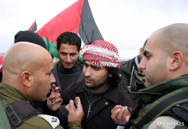 Israeli soldiers restrain Palestinian ,Israeli and foreign protesters during a protest against Israel's controversial separation barrier in the West Bank village of Massarah,near the biblical town of Bethlehem, on Februa...