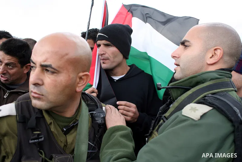 Israeli soldiers restrain Palestinian ,Israeli and foreign protesters during a protest against Israel's controversial separation barrier in the West Bank village of Massarah,near the biblical town of Bethlehem, on Februa...