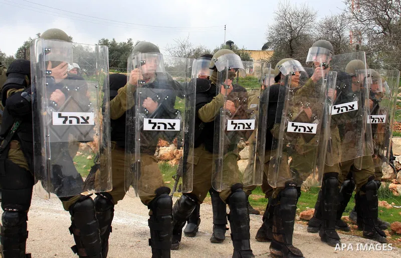 Israeli soldiers and border police stand guards during the weekly demonstration against Israel's separation barrier in the West Bank village of Bilin near Ramallah, Friday, Feb. 11, 2011. Photo by Wagdi Eshtayah