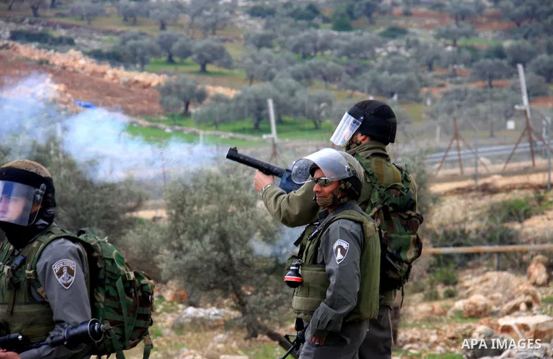 Israeli soldiers and border police fire tear gas at protestors during the weekly demonstration against Israel's separation barrier in the West Bank village of Bilin near Ramallah, Friday, Feb. 11, 2011. Photo by Wagdi Es...