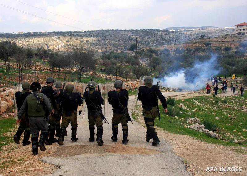 Israeli soldiers and border police fire tear gas at protestors during the weekly demonstration against Israel's separation barrier in the West Bank village of Bilin near Ramallah, Friday, Feb. 11, 2011. Photo by Wagdi Es...
